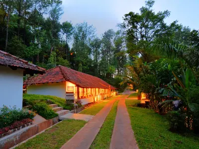 a pathway leading to a house in a garden at The Tamara Coorg in Kakkabe