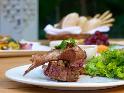 a plate of food with a piece of meat and a salad at The Tamara Coorg in Kakkabe