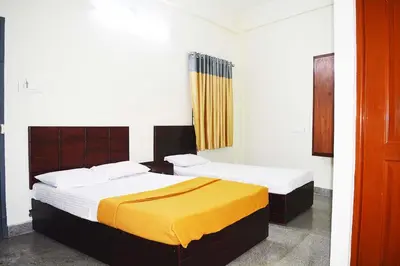 a bedroom with two beds with yellow sheets at Jippus Galaxy Budget Air port hotel in Cochin