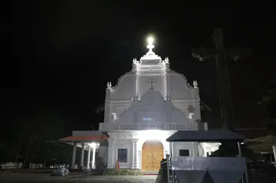 a large white building with a cross at night at Jippus Galaxy Budget Air port hotel in Cochin