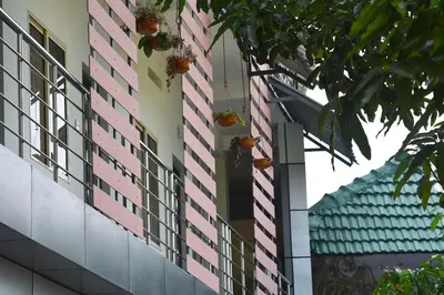 a pink building with plants on the side of it at Jippus Galaxy Budget Air port hotel in Cochin