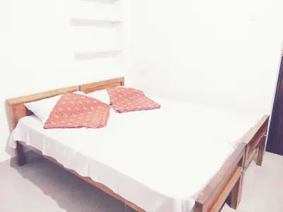 a white bed with two pillows on top of it at Nunu Homestay Guruvayoor in Guruvāyūr