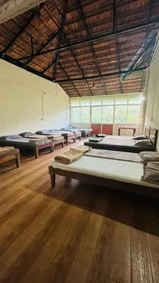 a large room with several beds in it at Coorg Heritage Hill View By The Avyaan in Madikeri
