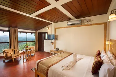 a bedroom with a large bed and a living room at The Porcupine Castle Resort in Madikeri