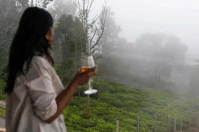 a woman is holding a glass of wine at StayVista at Aashirwaad Villa in Coonoor