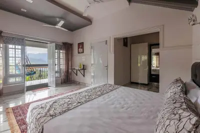 a large bedroom with a large bed and large windows at StayVista at Aashirwaad Villa in Coonoor