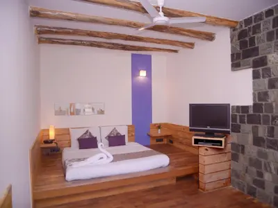 a bedroom with a bed and a flat screen tv at Club Mahindra Danish Villa, Ooty in Ooty