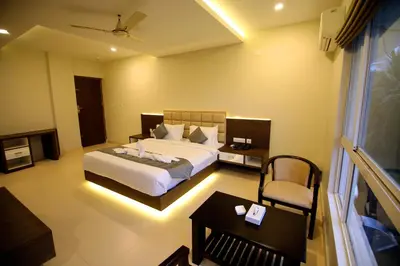a bedroom with a bed and a table and a chair at Hotel Le Sapphire in Sultan Bathery