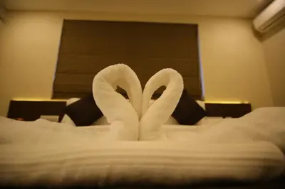 two swans made out of towels on a bed at Hotel Le Sapphire in Sultan Bathery