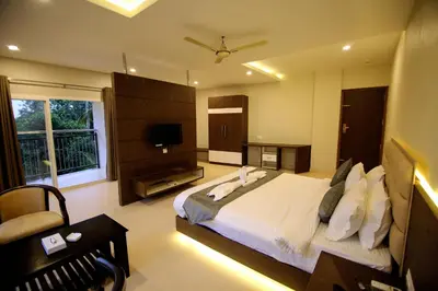 a bedroom with a large bed and a television at Hotel Le Sapphire in Sultan Bathery