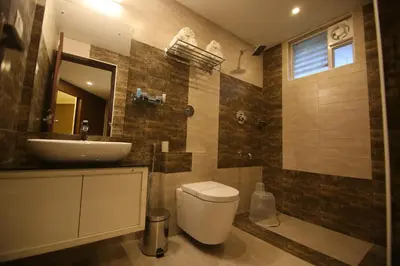 a bathroom with a white toilet and a sink at Hotel Le Sapphire in Sultan Bathery