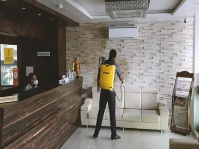 a person with a yellow backpack standing in a room at Heritage Inn in Mysore