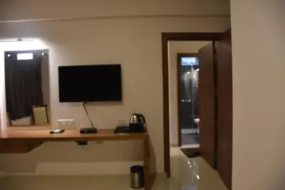 a hotel room with a television and a desk with a monitor at Heritage Inn in Mysore