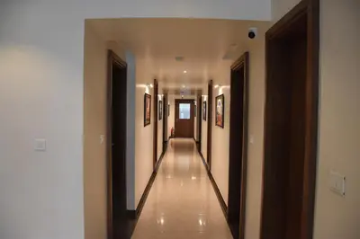 a hallway of a building with paintings on the walls at Heritage Inn in Mysore