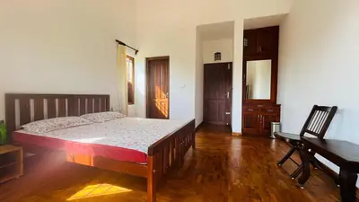 a bedroom with a bed and a desk and a piano at Pristine Hills in Meppādi