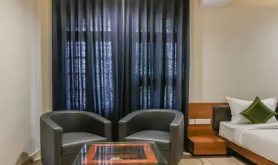 two chairs and a table in front of a curtain at Treebo Casino in Kozhikode