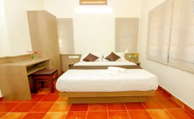 a bedroom with a bed and a desk in it at Dakshin Ghats in Tariyod