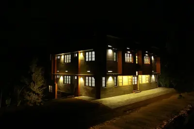 a building at night with lights in the dark at Dakshin Ghats in Tariyod