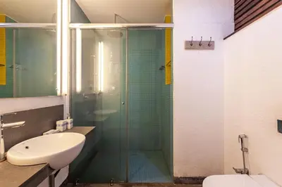 a bathroom with a sink and a glass shower at StayVista at Toya Toya River View in Kozhikode