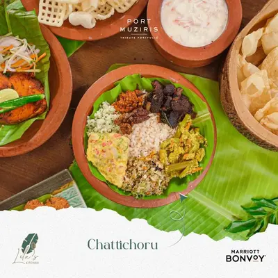a table topped with plates of food on top at Port Muziris, A Tribute Portfolio Hotel by Marriott, Kochi Airport in Nedumbassery