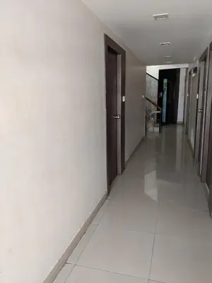 an empty hallway of a building with a hallway at Aashraya in Mysore