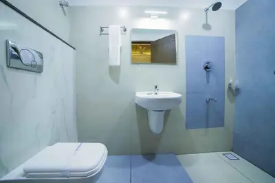 a white bathroom with a toilet and a sink at Bhavanam Regency Guruvayoor in Guruvāyūr