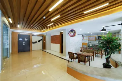 a lobby with a table and chairs and a dining room at Bhavanam Regency Guruvayoor in Guruvāyūr