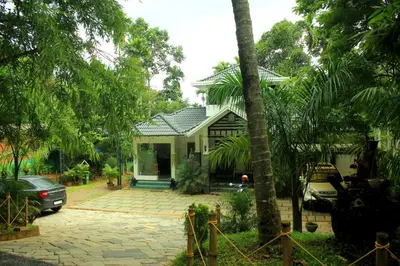 a house with a car parked in front of it at Vintage Garden Resort in Sultan Bathery
