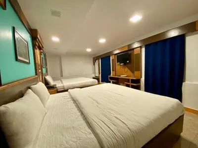 a hotel room with a bed and a television at Ganga's Sri Balaji Cottage in Ooty