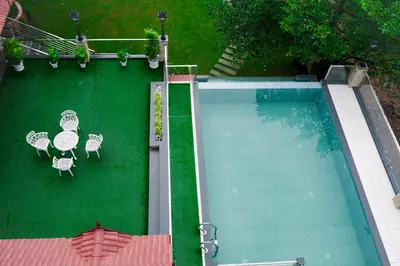 an overhead view of a swimming pool with tables and chairs at Athirappilly Rainland Resort in Athirappilly