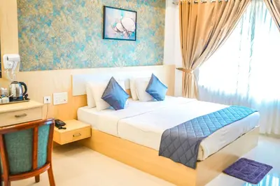 a bedroom with a large bed with blue pillows at Athirappilly Rainland Resort in Athirappilly