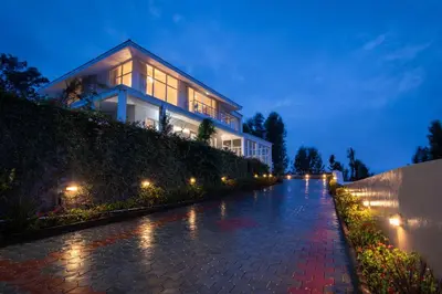 a house with lights on the side of a street at StayVista at The Lilly Ooty with Breakfast in Ooty