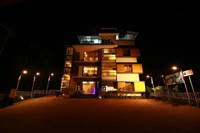 a tall building at night with lights on at Bonita Banasura in Vythiri