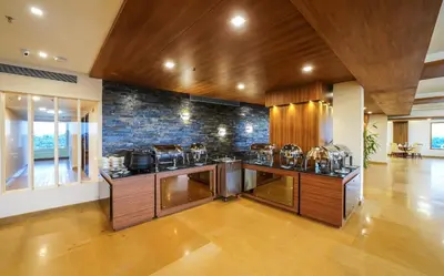 a kitchen with a counter with pots and pans at KPM TRIPENTA HOTEL in Kozhikode
