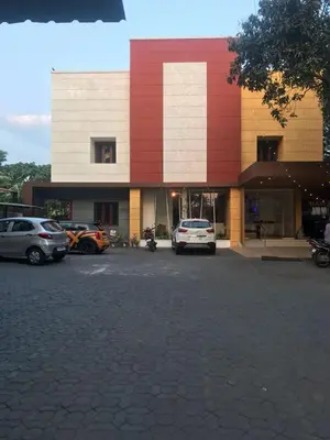 a parking lot with cars parked in front of a building at Kallada Sangeetha Hotels in Trichūr