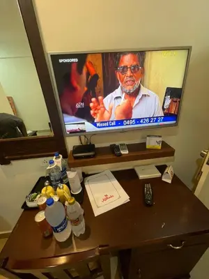 a television on a desk in a room at Kallada Sangeetha Hotels in Trichūr