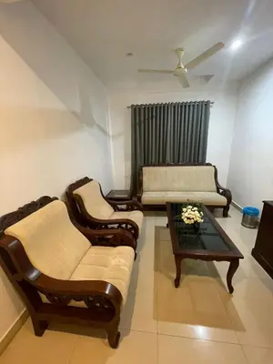 a living room with two couches and a coffee table at Kallada Sangeetha Hotels in Trichūr