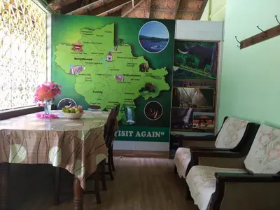 a table with a map of australia on a wall at Woodside Homestay Wayanad in Batheri