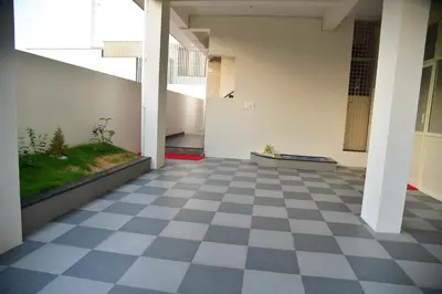 an empty hallway of a building with a checkered floor at Elegant Serviced Apartment in Mysore