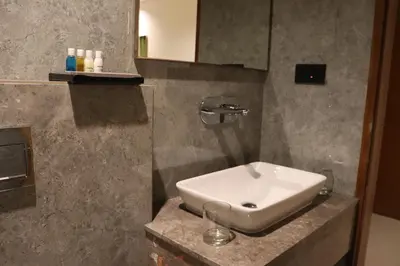 a bathroom with a white sink and a mirror at Hotel Park Residency Thrissur in Trichūr