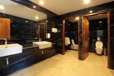 a bathroom with two sinks and a toilet at Hotel Park Residency Thrissur in Trichūr