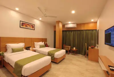 a hotel room with two beds and a television at Hotel Park Residency Thrissur in Trichūr