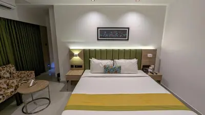 a hotel room with a bed and a chair at Hotel Park Residency Thrissur in Trichūr