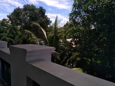a white fence with trees in the background at Ocean Stay in Nedumbassery