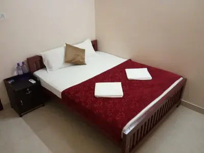 a bedroom with a bed with two towels on it at Ocean Stay in Nedumbassery