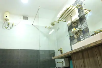 a bathroom with a shower with a glass wall at Lalys Residency in Trichūr