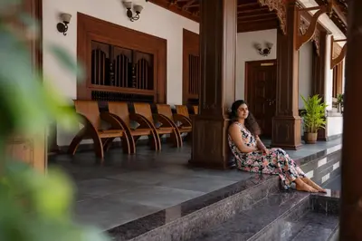 a woman sitting on the steps of a building at Villa De 1945 in Mahe