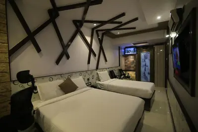 a hotel room with two beds and a television at Beverly villa in Ooty