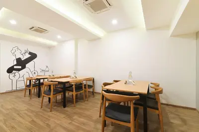 a restaurant with tables and chairs in a room at Super Townhouse Srm Kuppakonam Pudur in Coimbatore