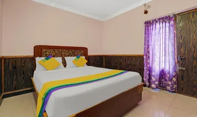 a bedroom with a large bed with a rainbow blanket at Itsy Hotels Rain Forest, 1 km from Rose Garden in Ooty